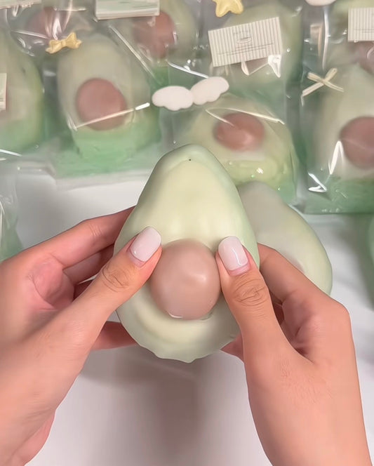 Cute avocado cracking clay squishy with crispy shell and soft clay filling for sensory play.